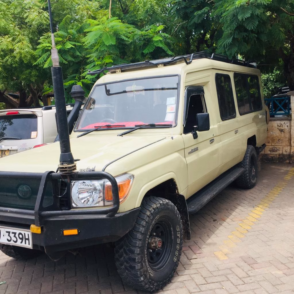 Tourist safari van picking up guests from a beach hotel in Diani for Shimba Hills Day Safari