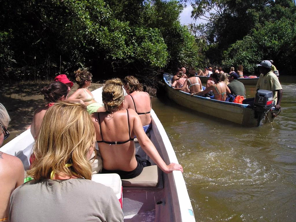 ourists enjoying a canoe ride through mangroves on a Funzi Island day trip from Diani Beach.