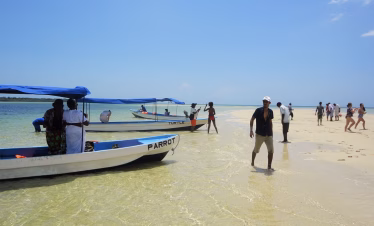 White sandbank near Funzi Island with crystal-clear water and tourists sunbathing during a day tour from Mombasa.