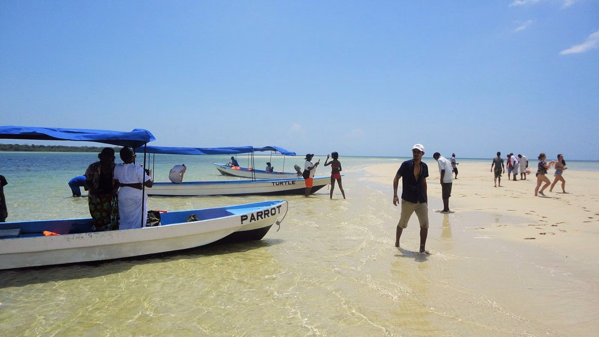 White sandbank near Funzi Island with crystal-clear water and tourists sunbathing during a day tour from Mombasa.